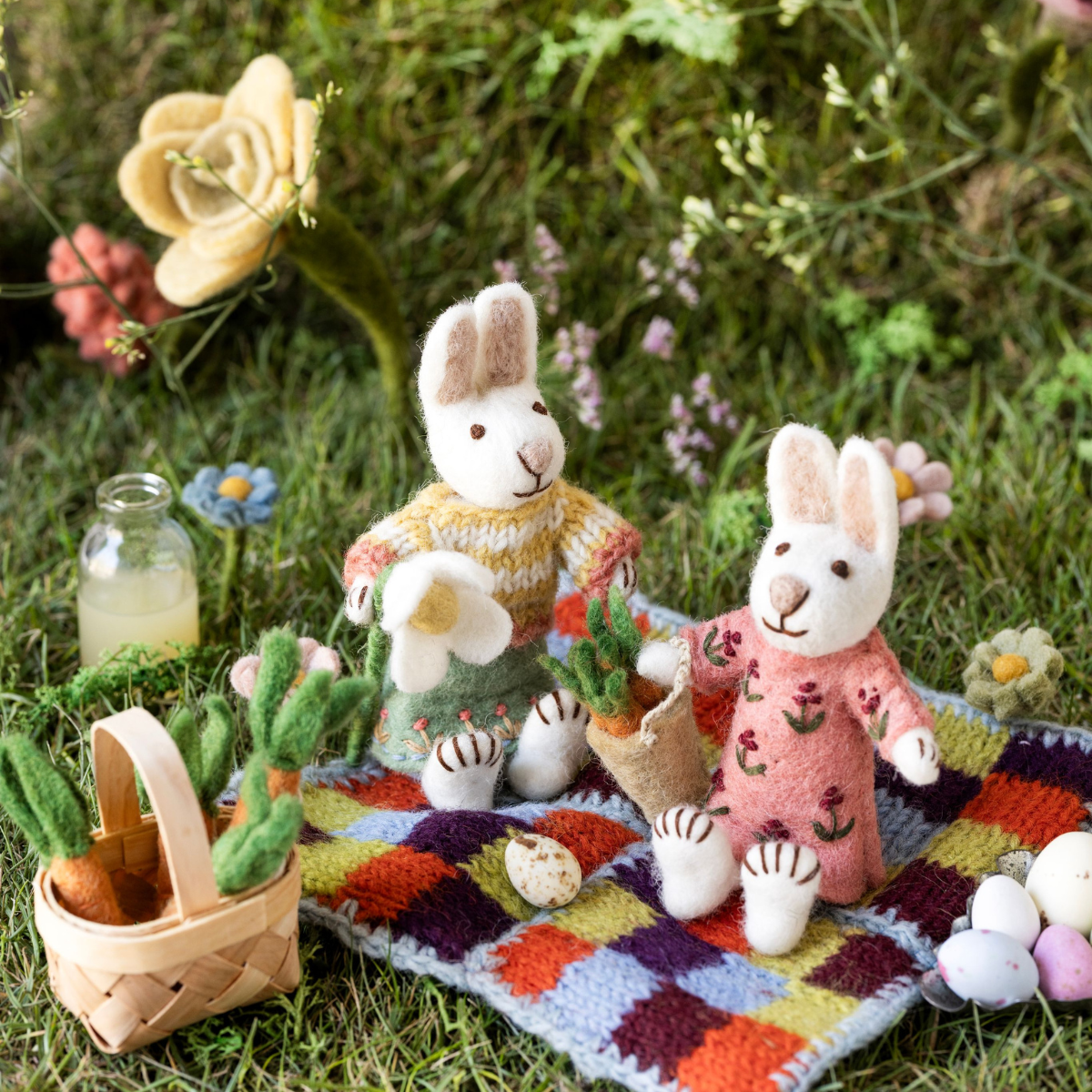 Gefilzte Hasenfiguren von Gry & Sif beim Osterpicknick auf einer Frühlingswiese.