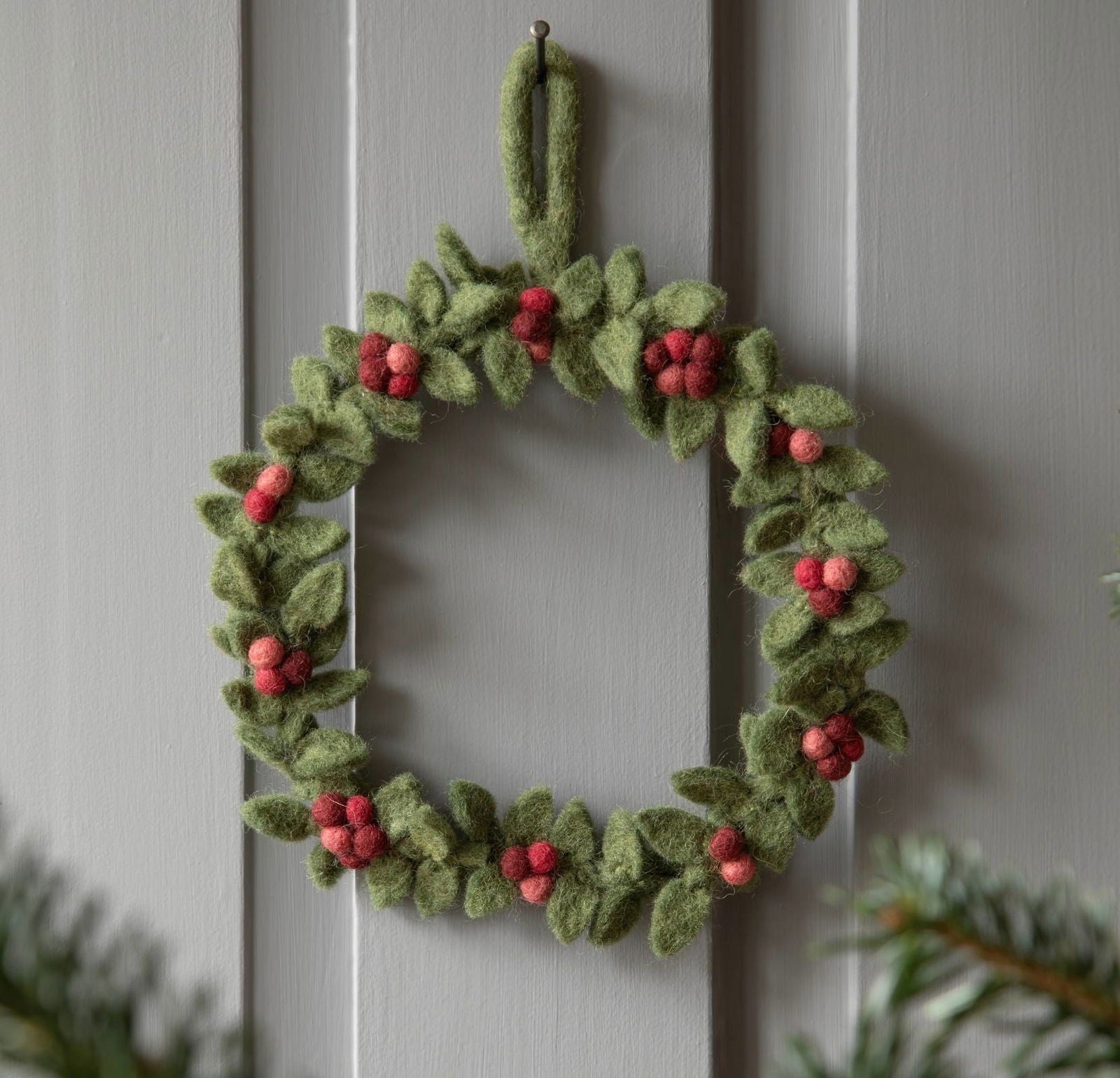 Handgefilzter kleiner Türkranz aus Wollfilz in Grün mit roten Beeren – nachhaltige Weihnachtsdeko von Gry & Sif, fair gehandelt und liebevoll handgemacht